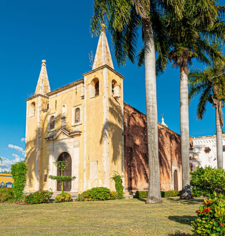 iglesia amarilla con palmeras en los costados